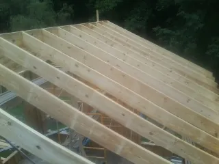 New roof rafters set over an addition before sheathing in Clinton